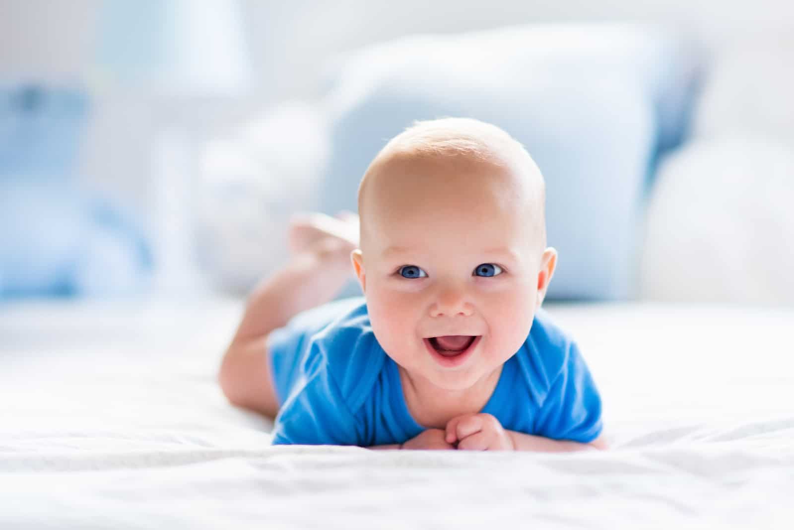 a smiling child crawls on the floor