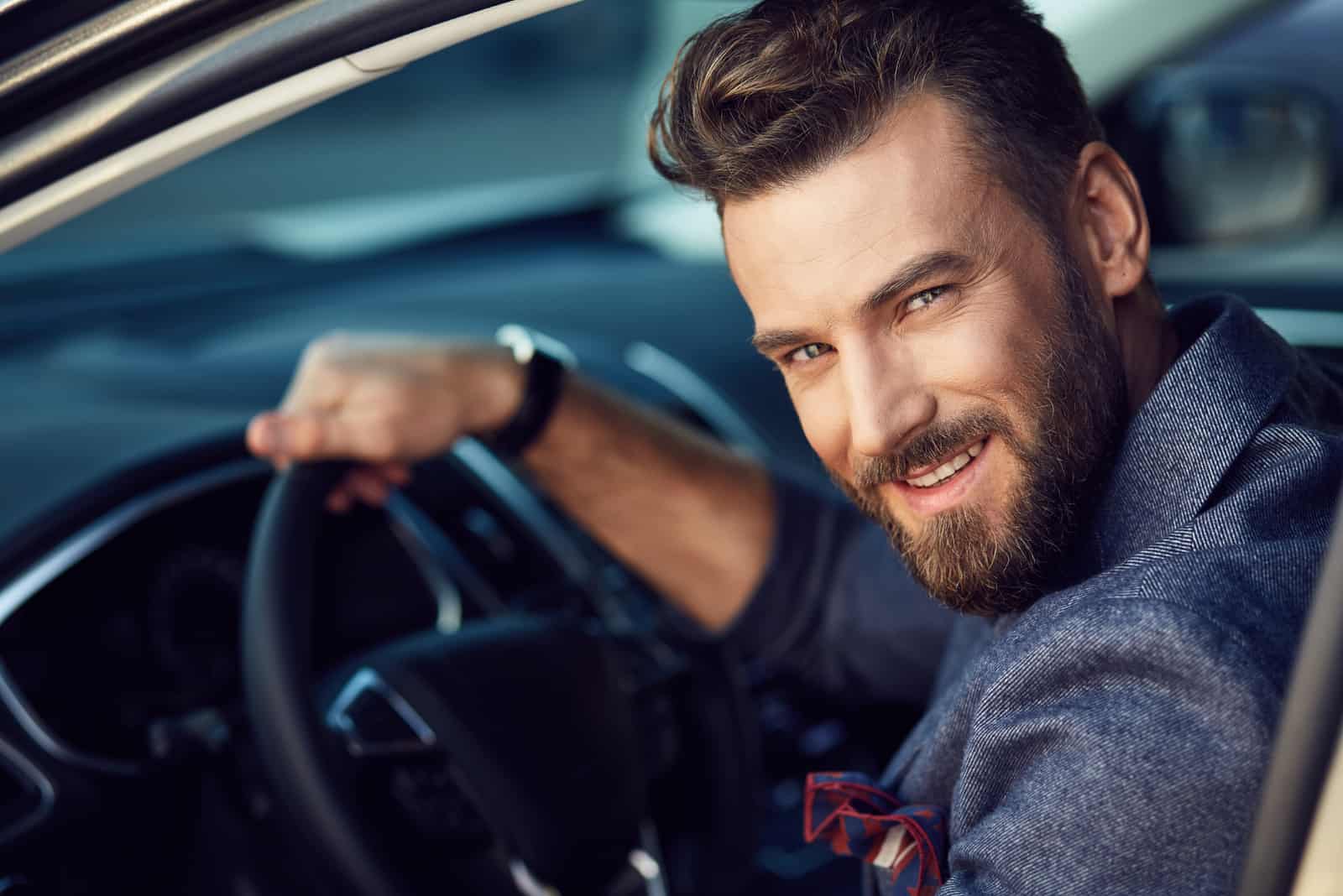 un hombre sonriente sentado en el coche