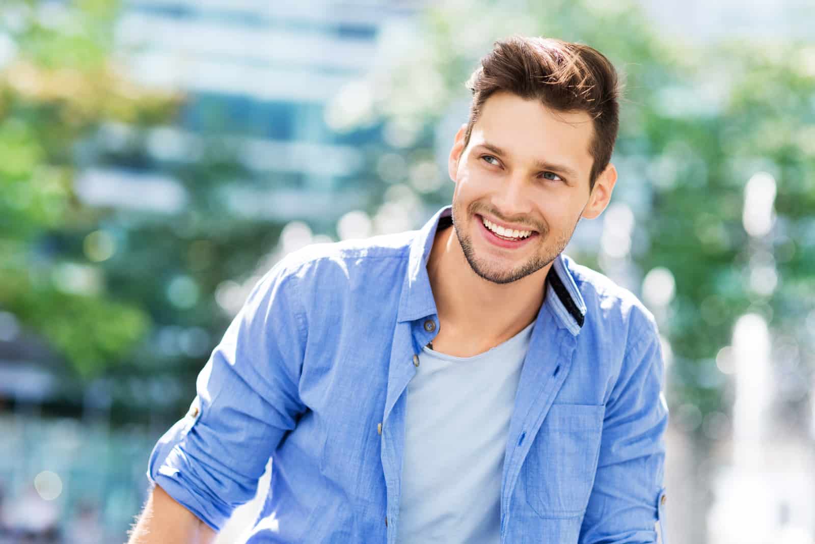 un hombre sonriente se levanta y mira hacia otro lado