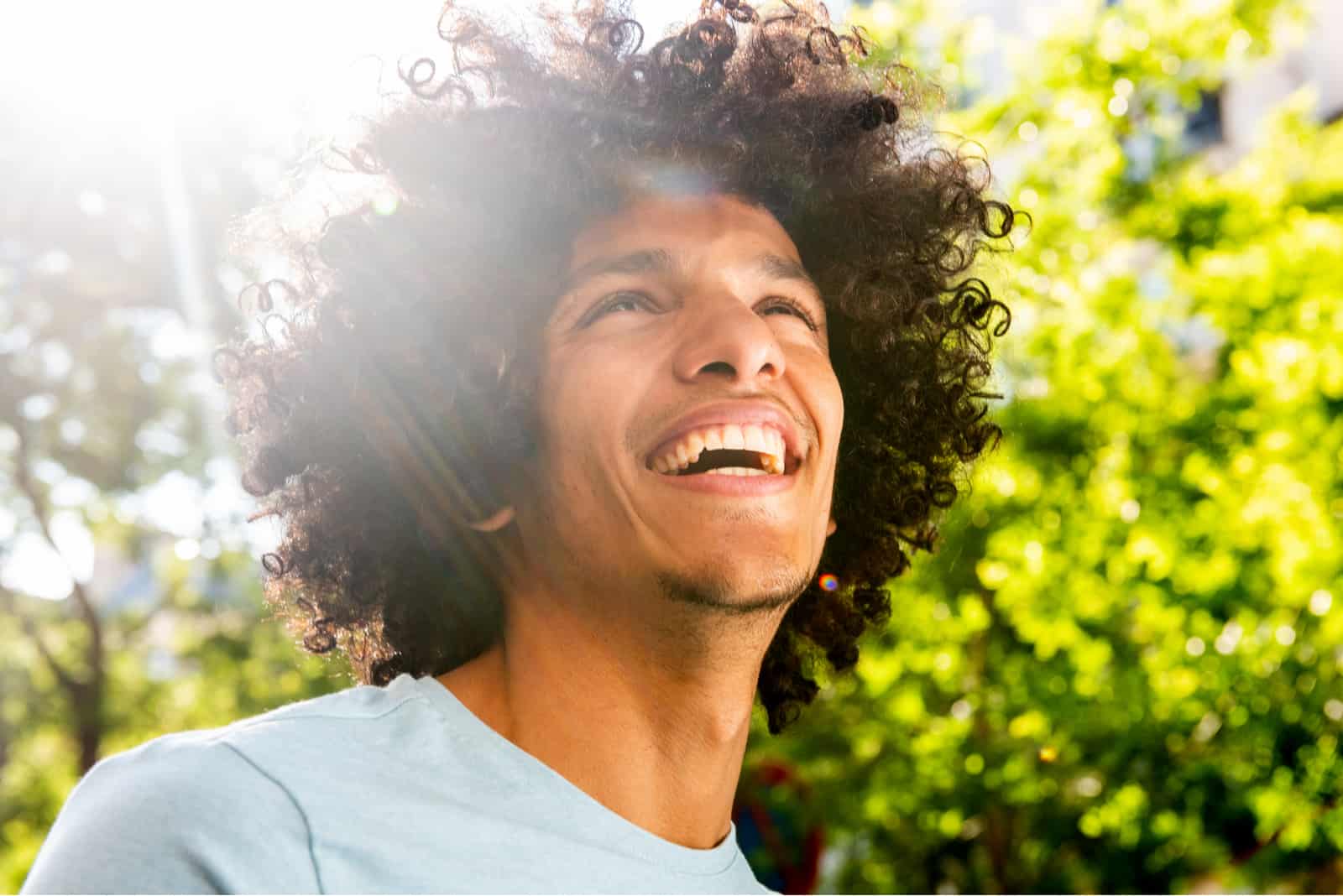 un hombre sonriente con el pelo encrespado