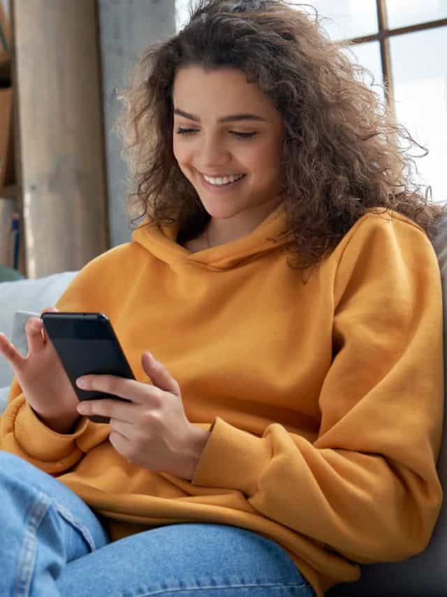 woman sitting on sofa while texting