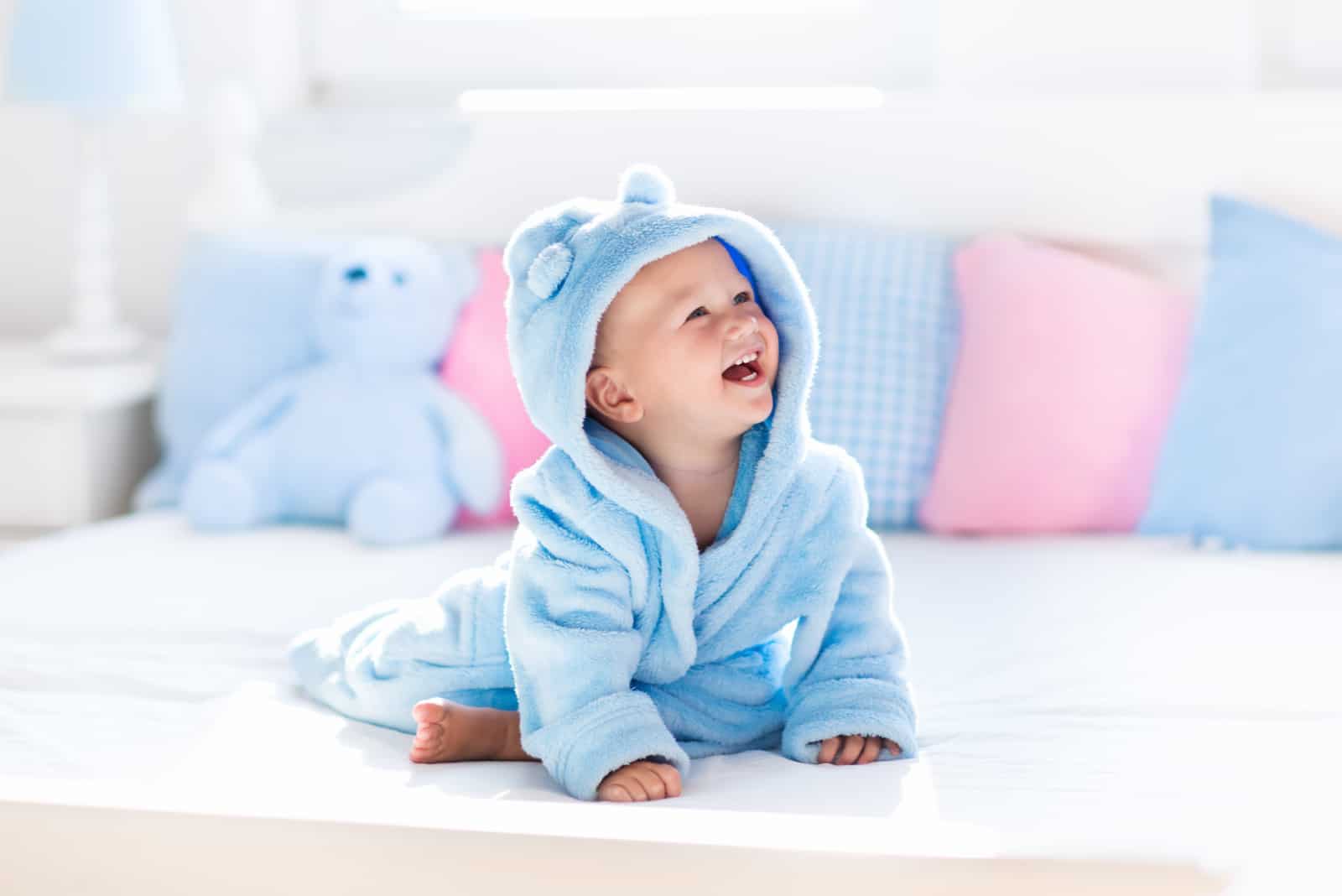 laughing baby boy in soft bathrobe