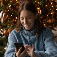 woman smiling and looking at her phone
