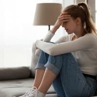 sad woman sitting on sofa