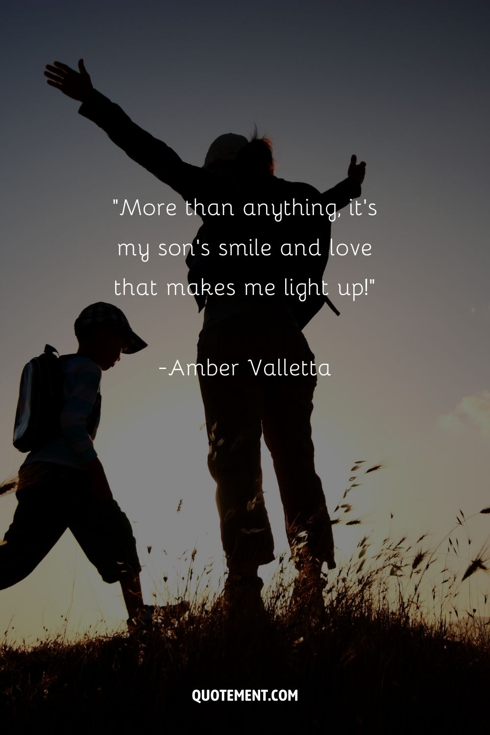 A boy and a woman in a field highlighted by the setting sun