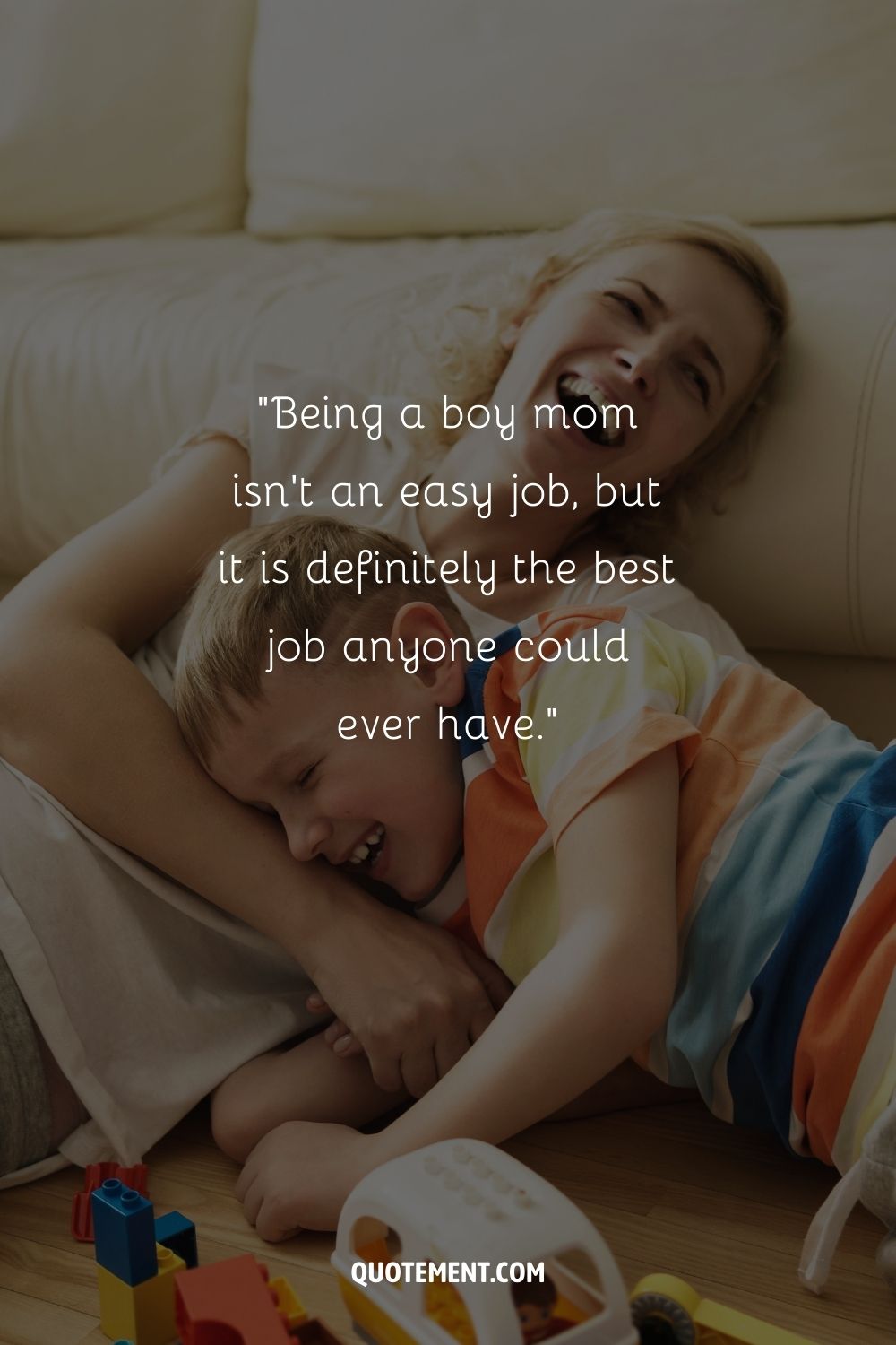 A mother playing with her son draped over her on a couch