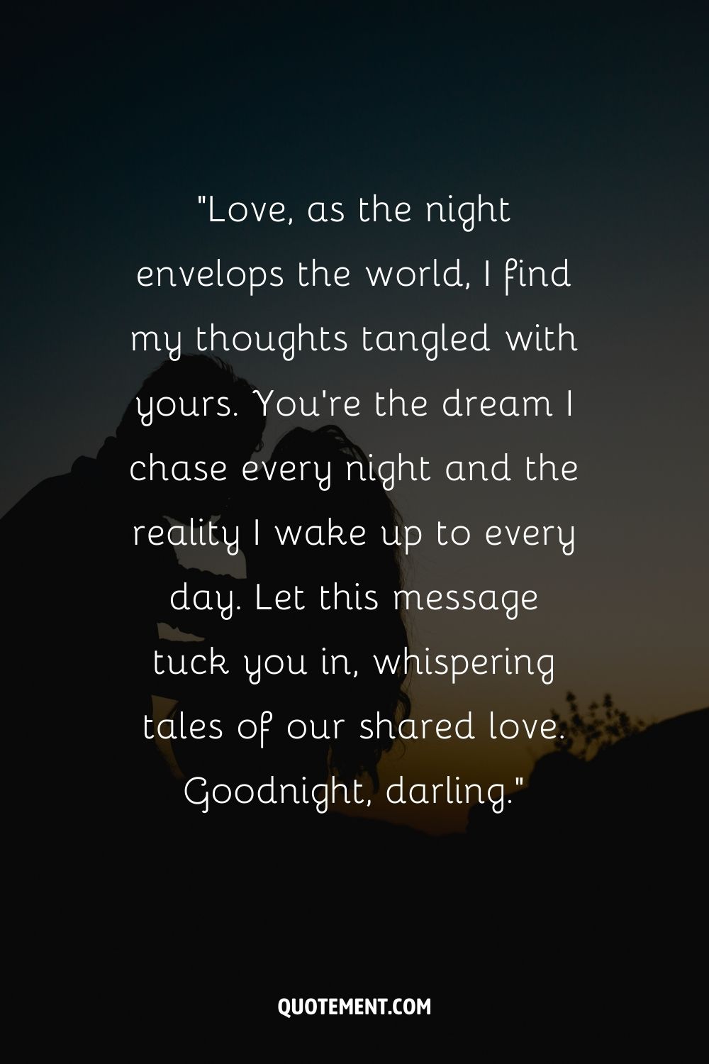 The silhouette of a couple's kiss against a dark blue twilight sky