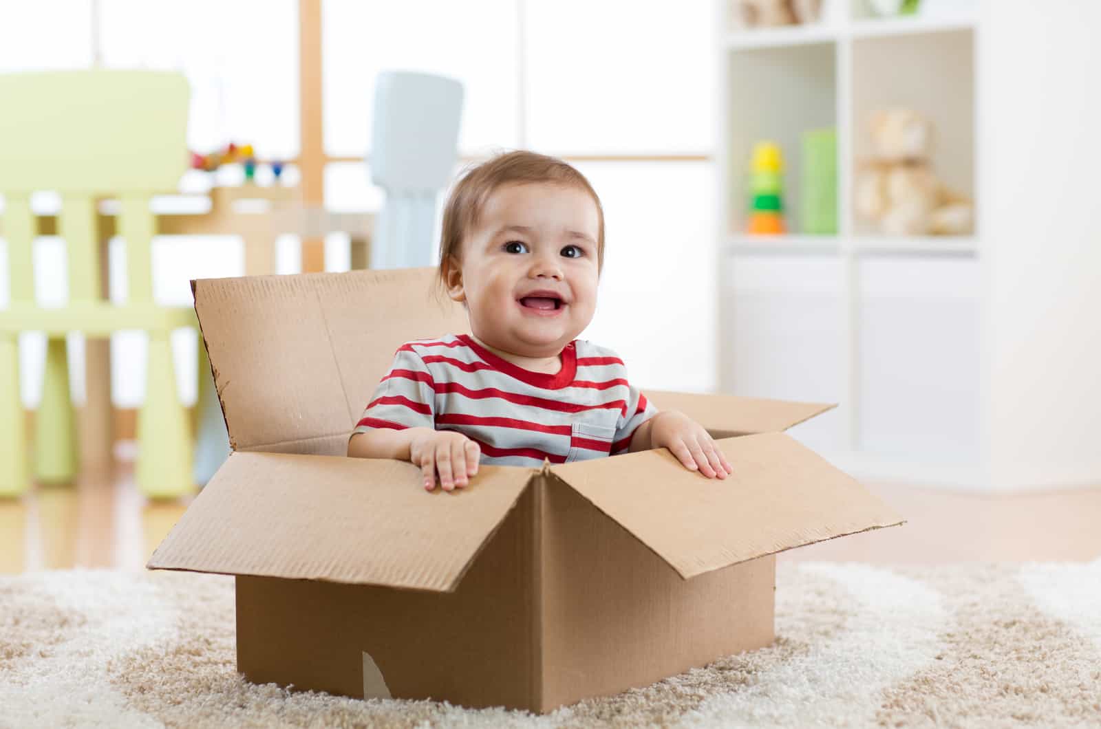 bebé feliz sentado en una caja