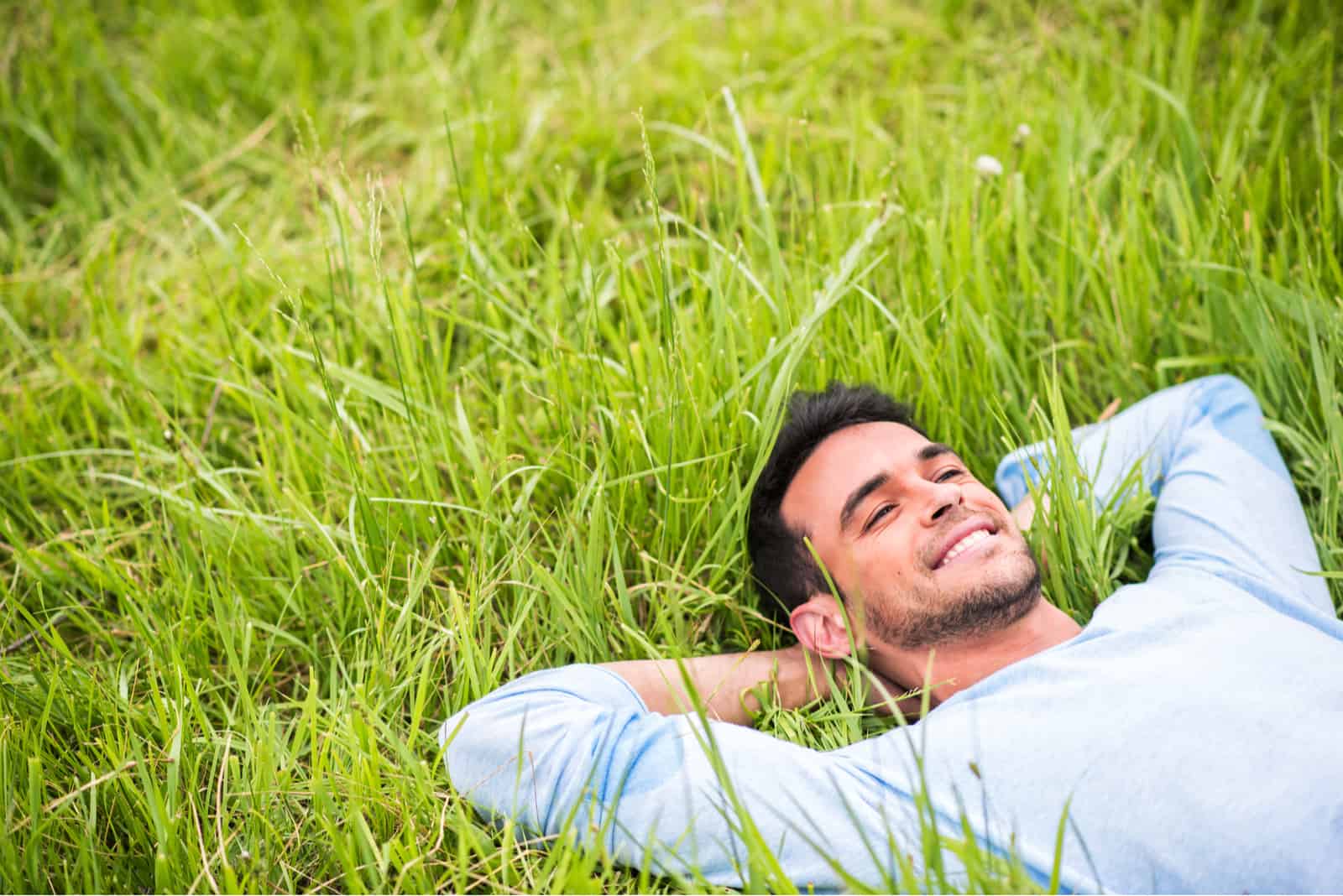 hombre feliz tumbado en la hierba verde
