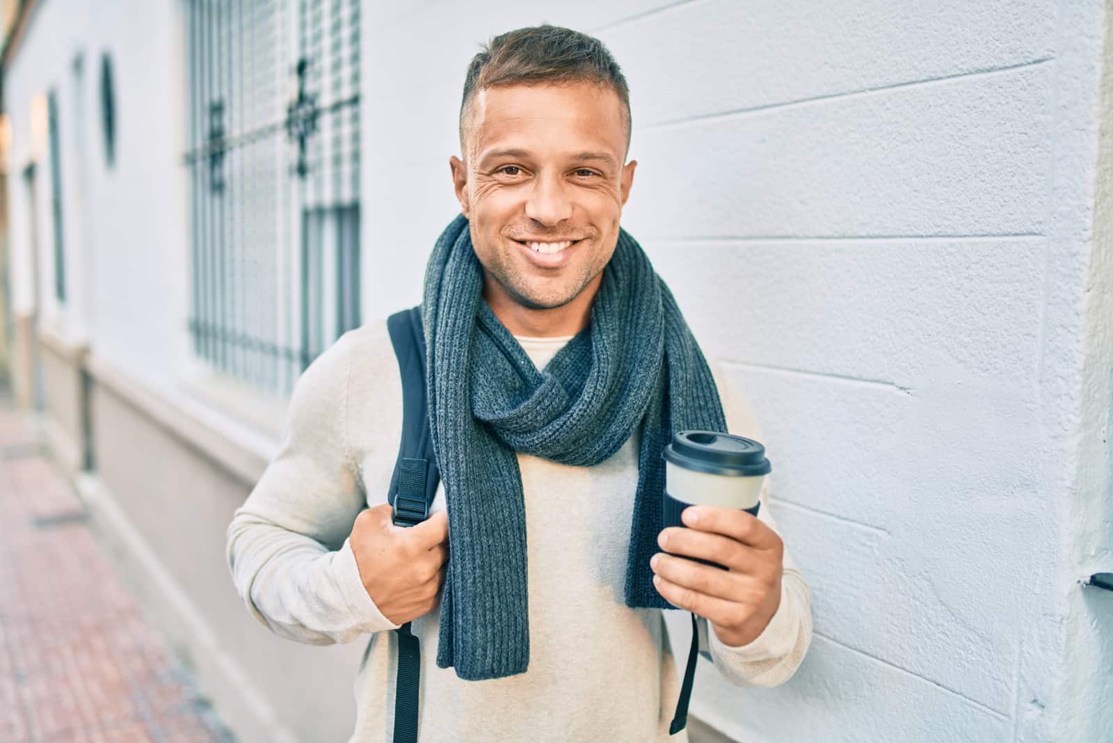 smiling man holding a cup of coffee