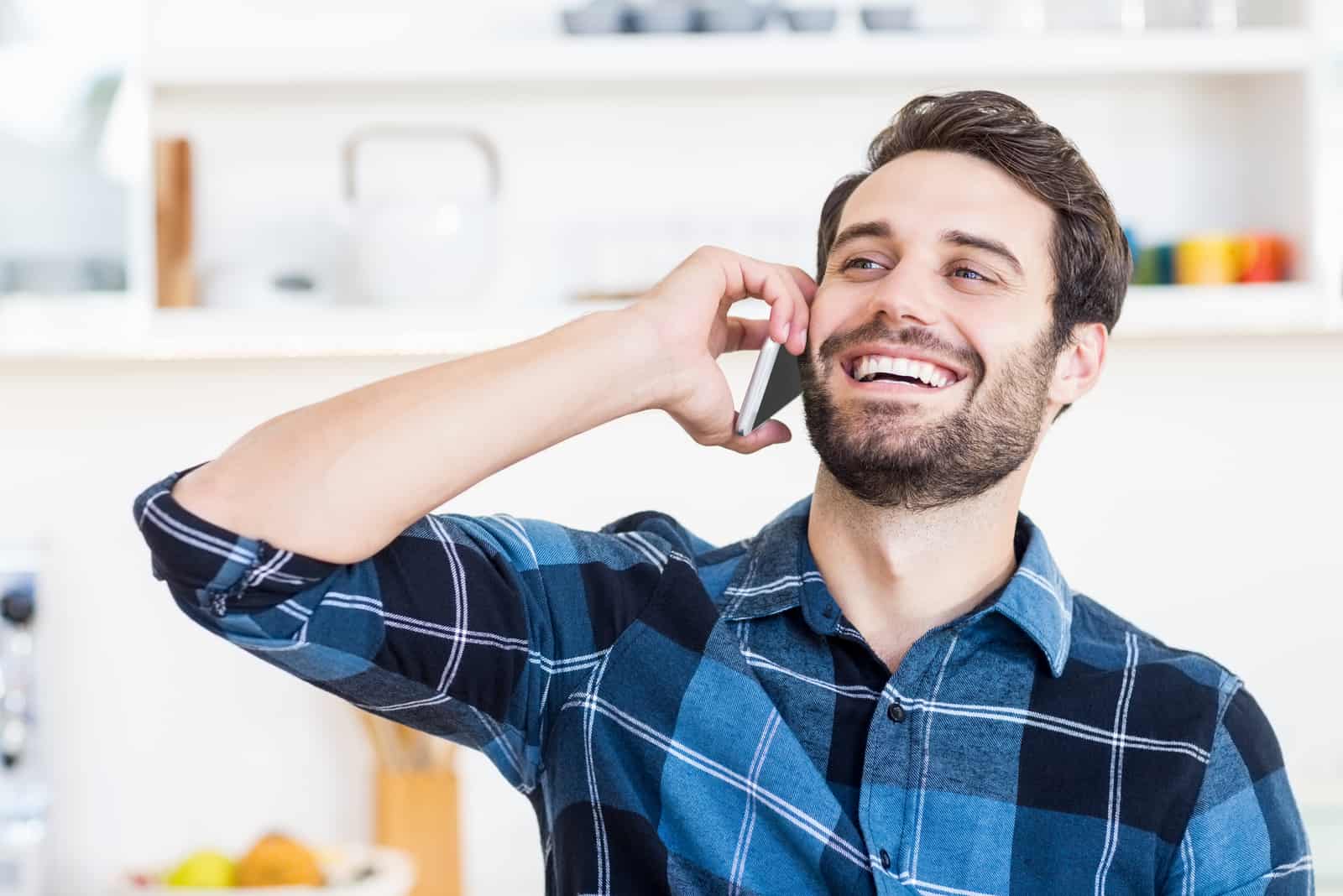 hombre sonriente hablando por el móvil