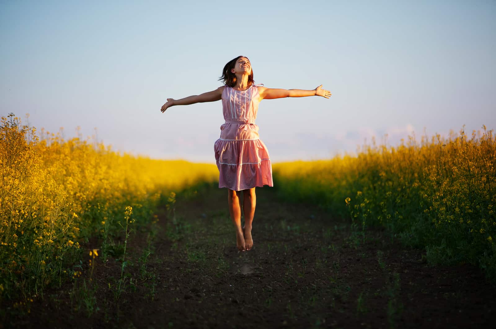 young woman jumping in field