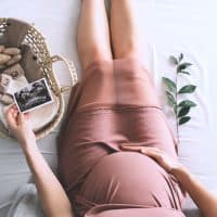 pregnant woman sitting and looking an ultrasound photo