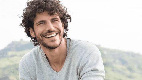 a smiling man with frizzy hair