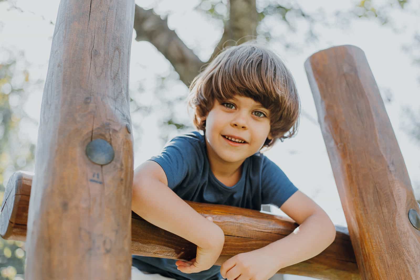 a smiling boy is playing outside