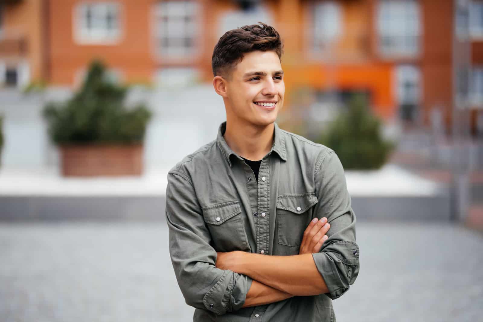 a smiling boy stands in the street and looks into the distance