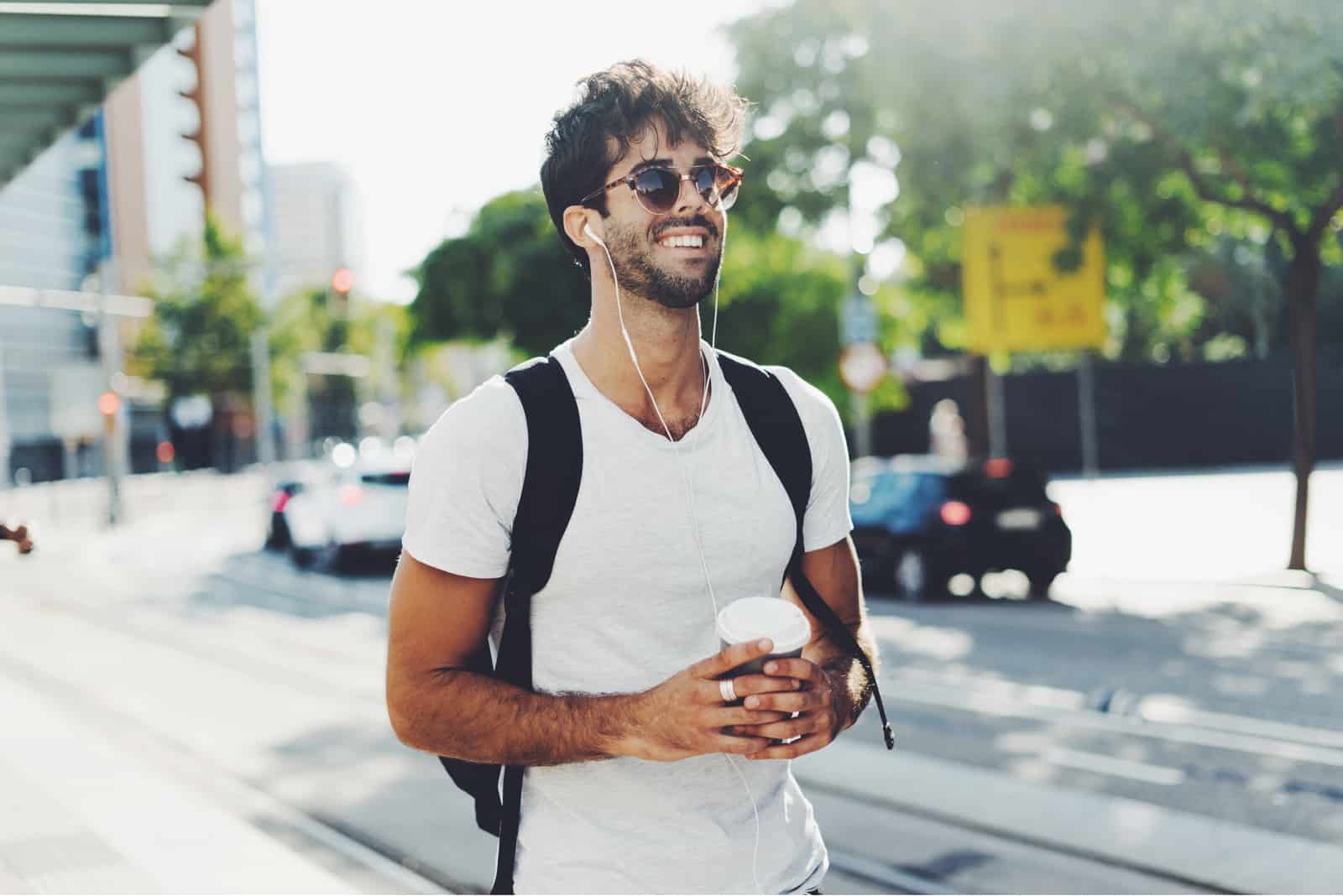 a smiling man walks down the street