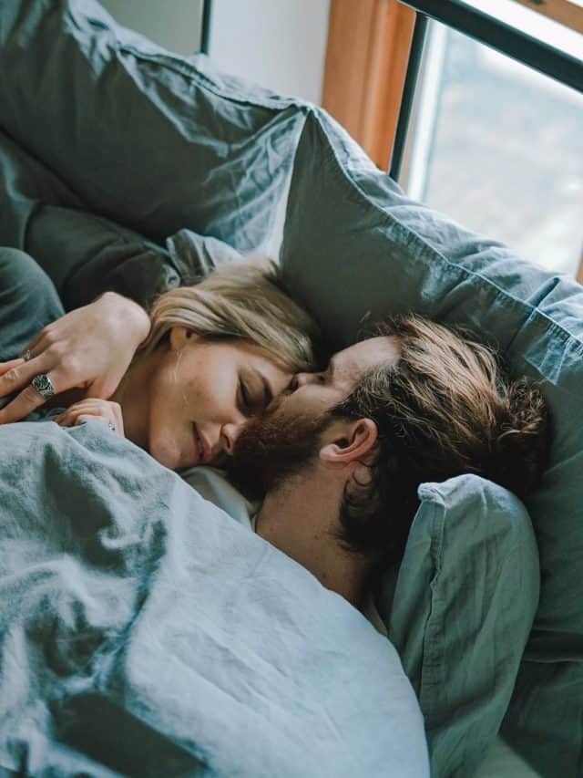 couple in bed romantic forhead kiss