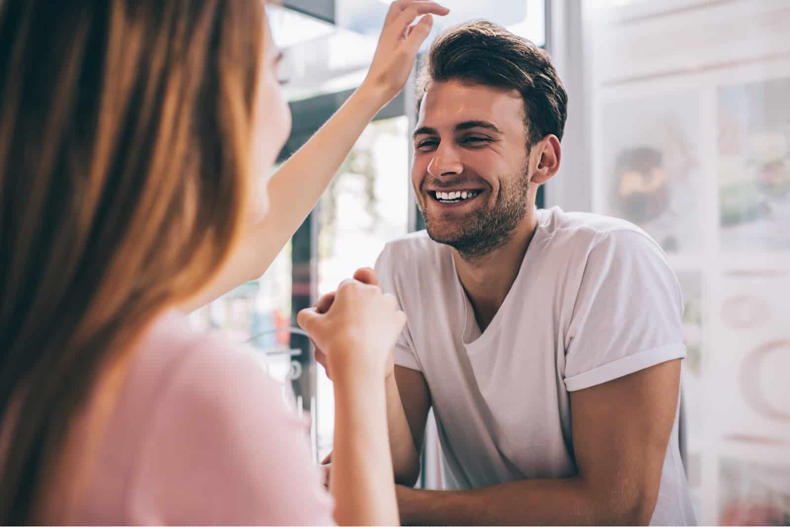 hombre romántico riendo en el amor de la mano de su pareja durante el coqueteo