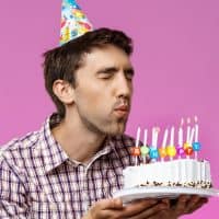 man blowing out candles