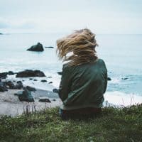 sad woman sitting by sea