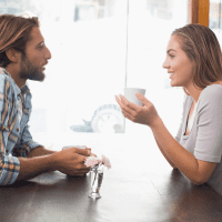 smiling man and woman sitting at the table and talking