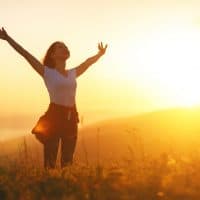 mujer feliz de pie en el campo