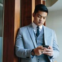 man in suit texting his girlfriend