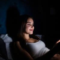 mujer enviando mensajes de texto por la noche