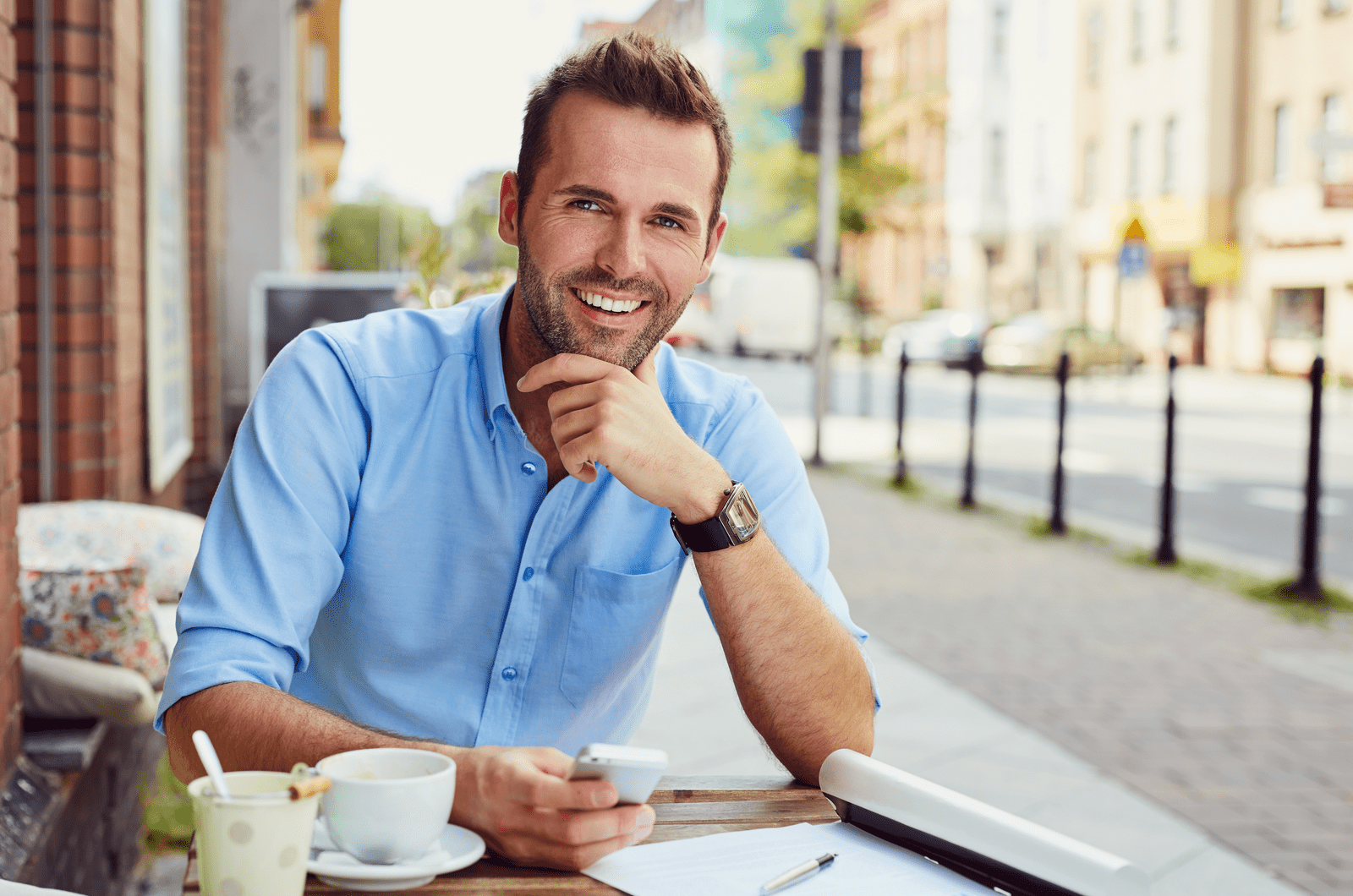 un hombre sonriente sentado al aire libre