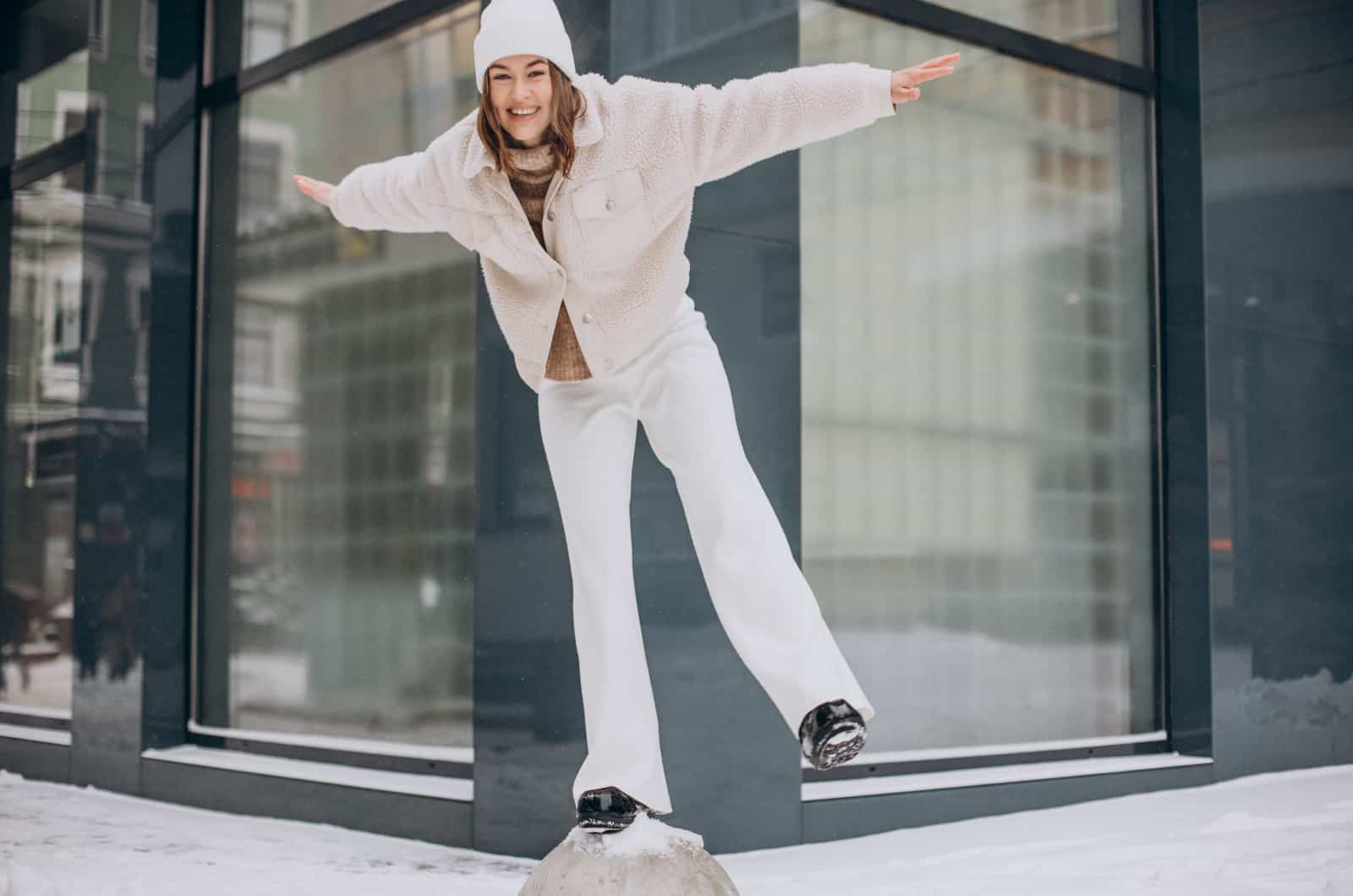 woman in beige outfit standing on a log