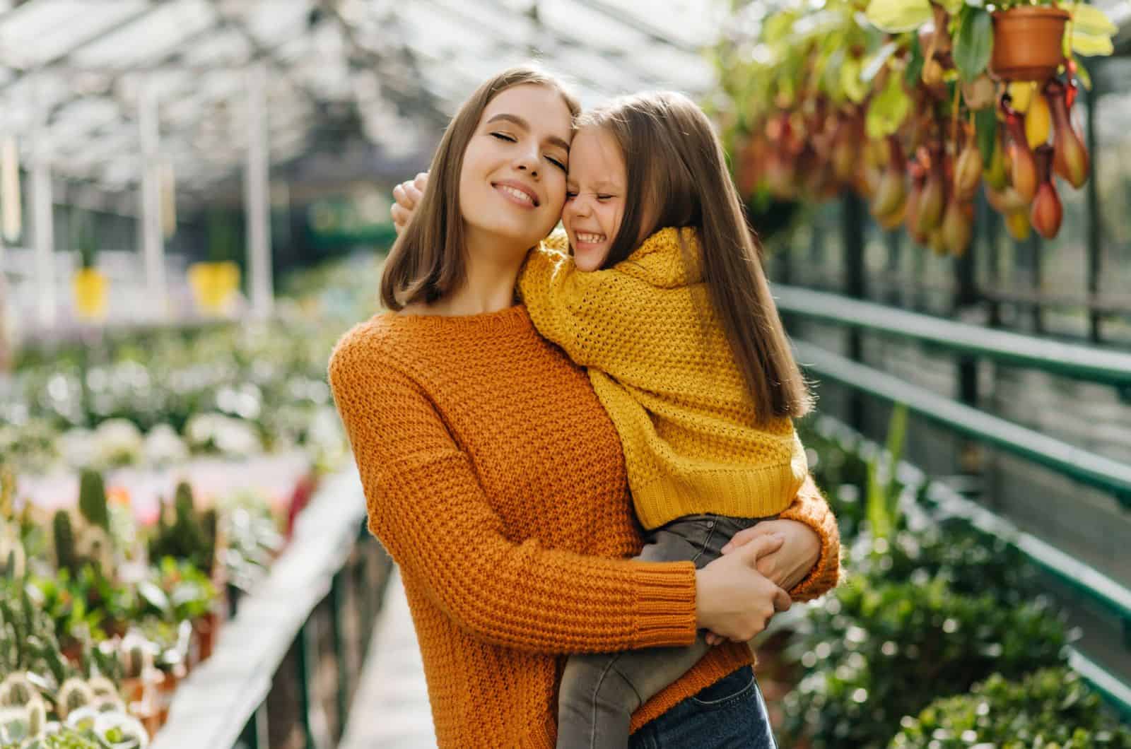 young woman holding little girl in arms