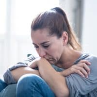 sad woman sitting on sofa