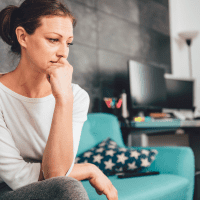 a crying woman is sitting on the couch