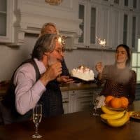 older man blowing out candles