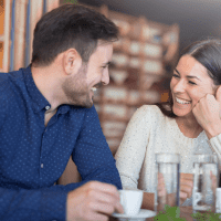 smiling man and woman sitting next to each other and talking