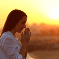 a woman with long brown hair is praying