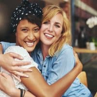 two sisters-in-law hugging