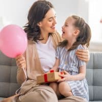 an aunt hugging with niece on the couch