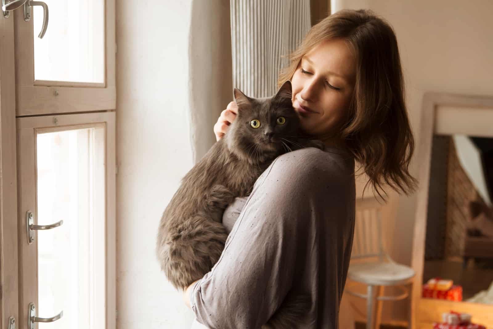 Mujer joven jugando con gato en casa