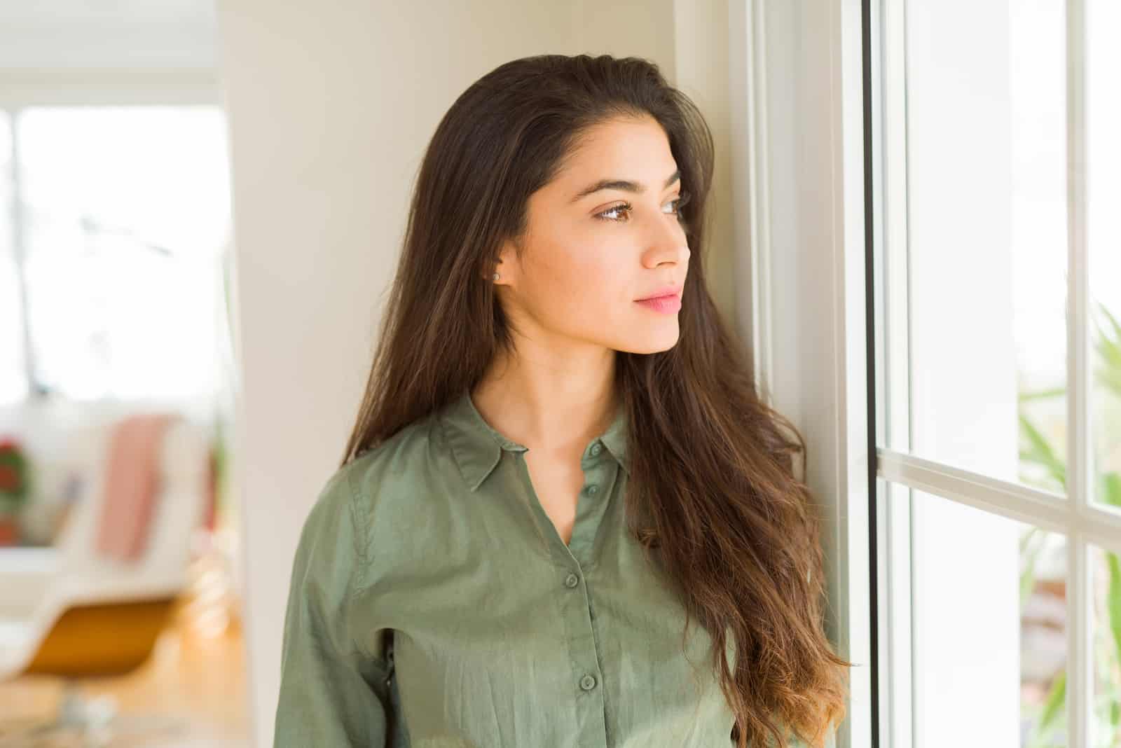 hermosa mujer pensando junto a la ventana