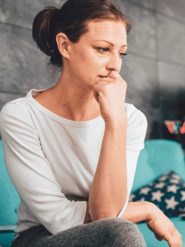 a crying woman is sitting on the couch