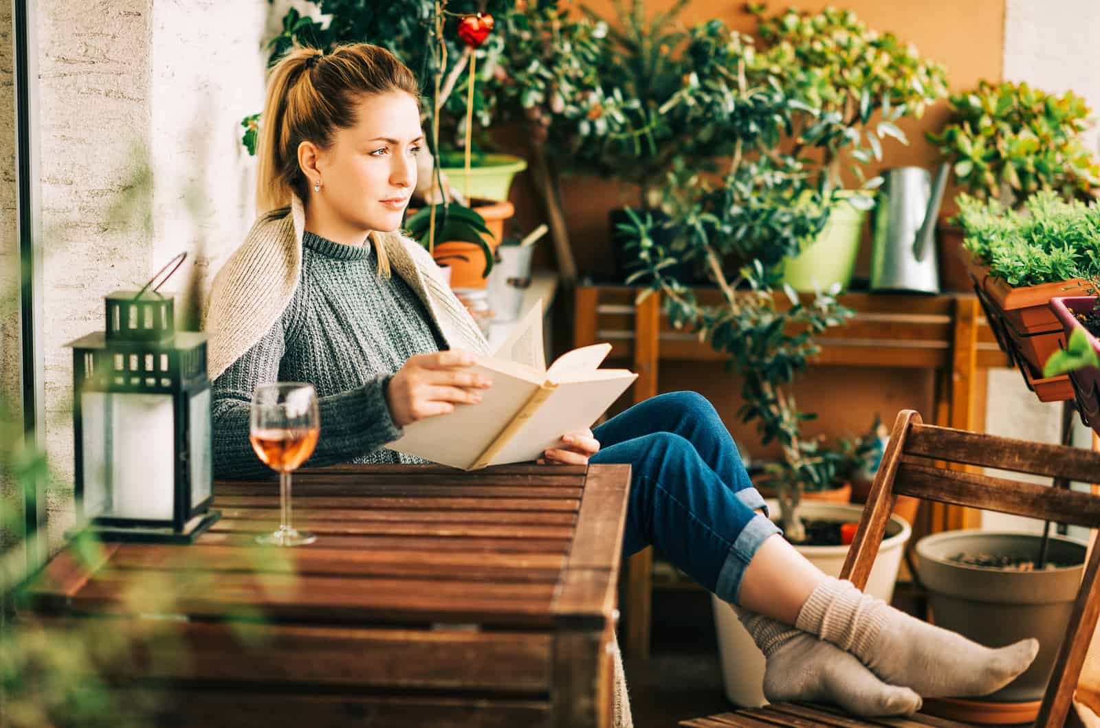 woman reading a book drinking wine