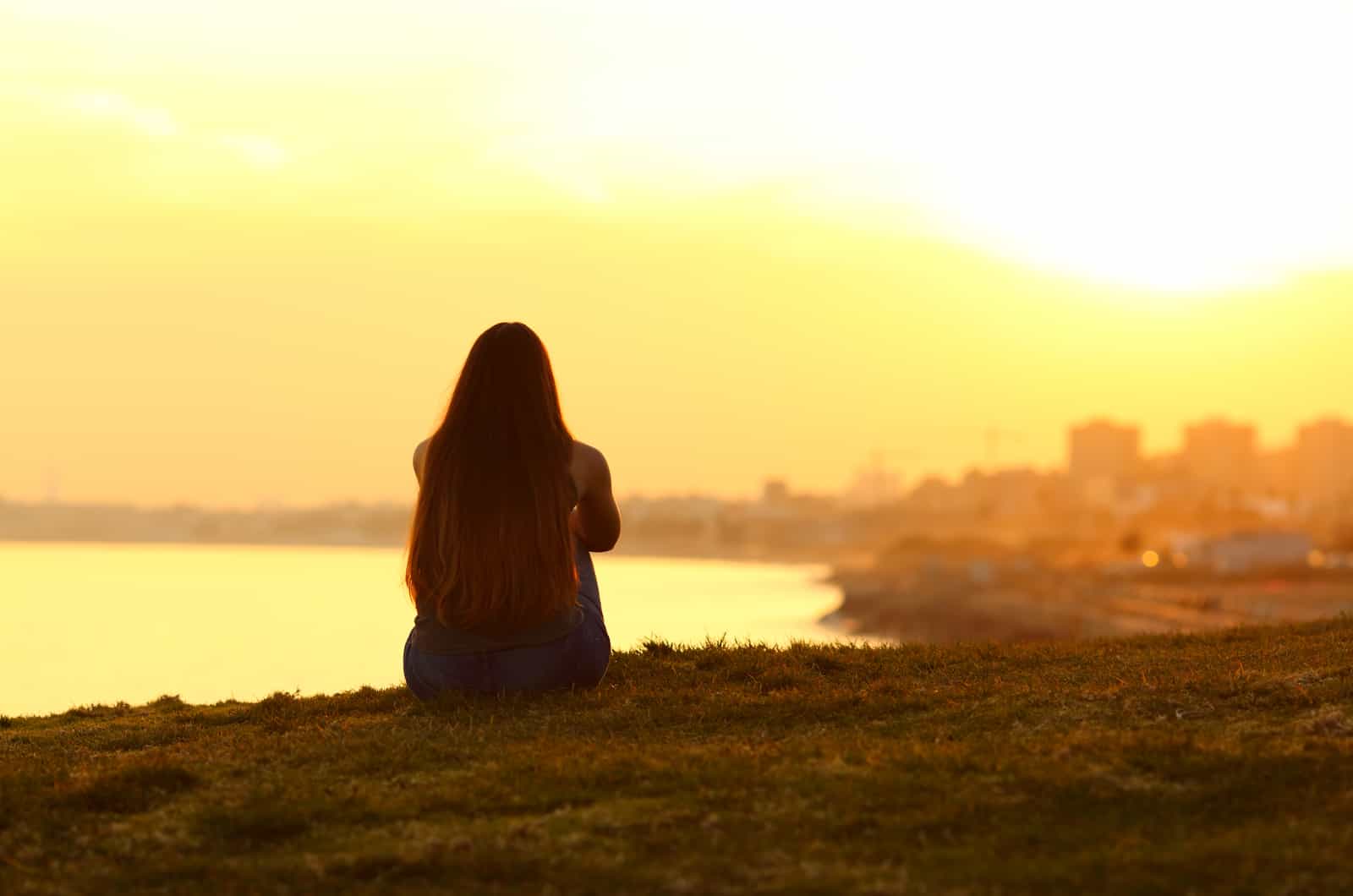 woman sitting outside looking at sunset