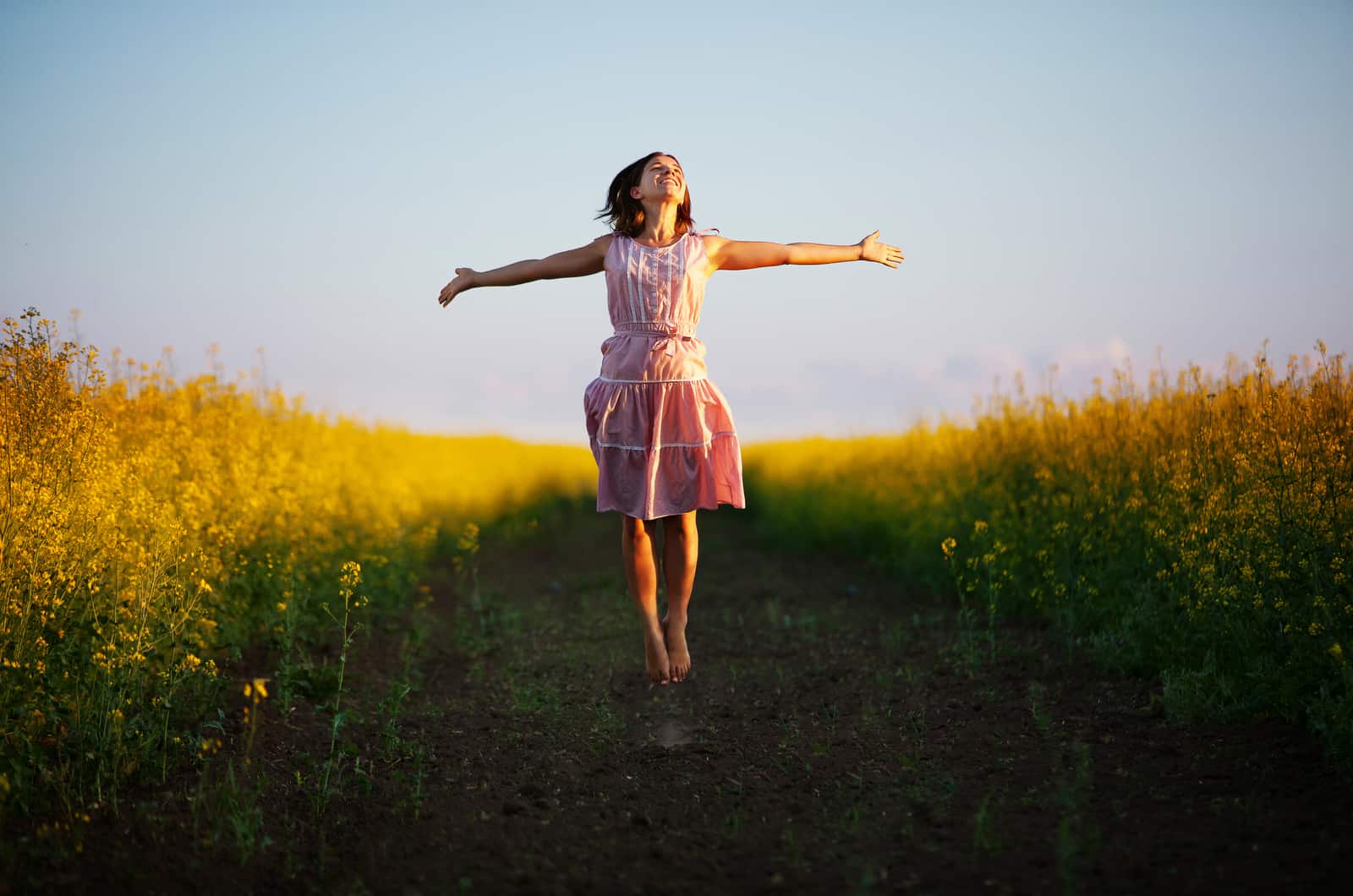 mujer joven saltando en el campo