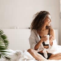 mujer feliz tomando café por la mañana