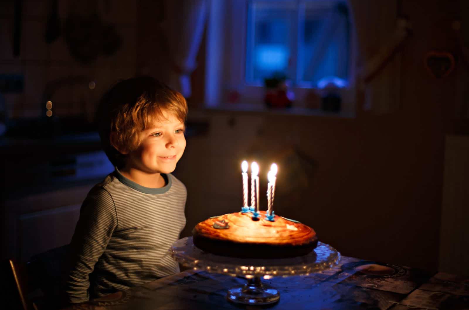 little boy blowing out candles