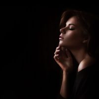 side portrait of a woman with dark background