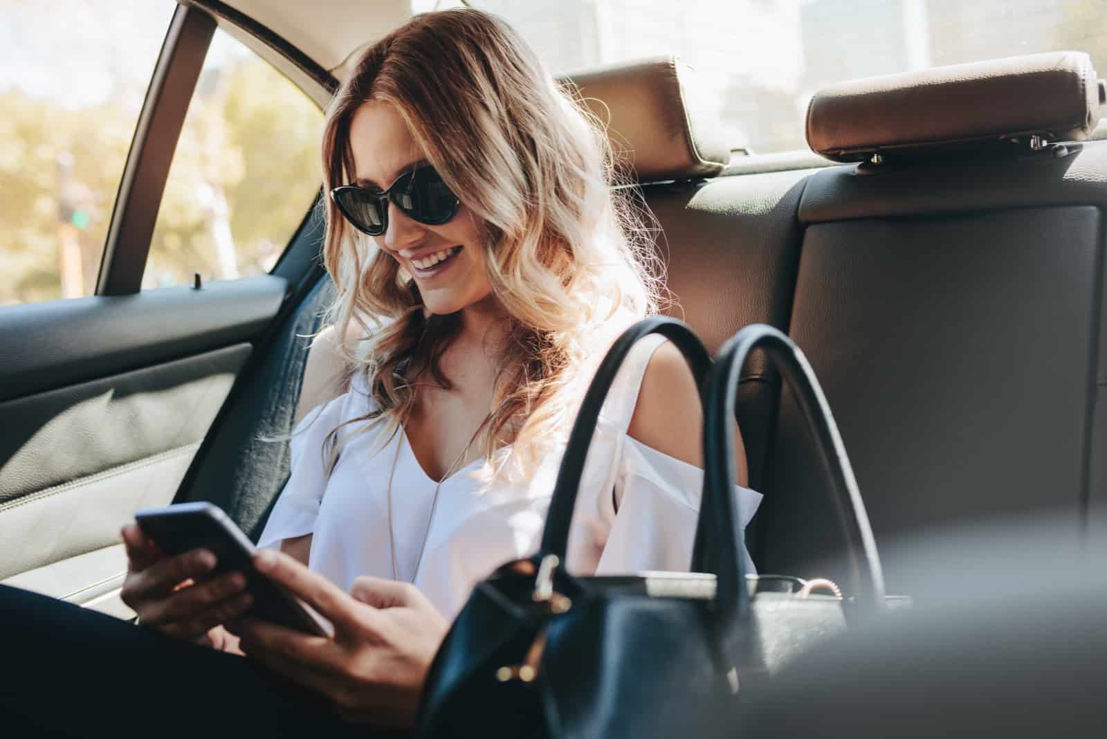 woman texting while sitting in car