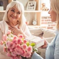 woman giving birthday presents to her mom